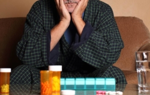 Senior man sitting on couch depressed about medications