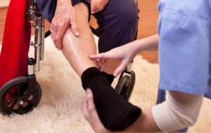 Doctor examining leg of woman in wheelchair