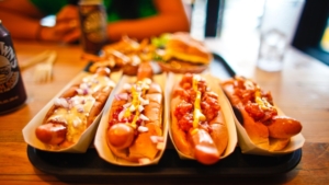 Hotdogs smothered in ketchup on table