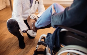Doctor examining patient with pad in wheelchair
