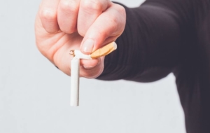 Man breaks cigarette and holds it up