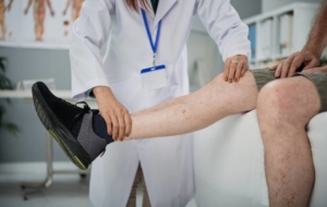 Doctor examining mans leg to prevent amputation