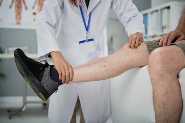 Doctor examining mans leg to prevent amputation