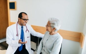 Senior woman talking to vascular specialist about PAD hair loss on leg treatment