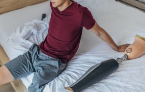 Man sitting on bed with fake leg next to him