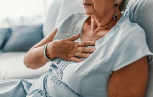 Woman holding chest worried about heart attack