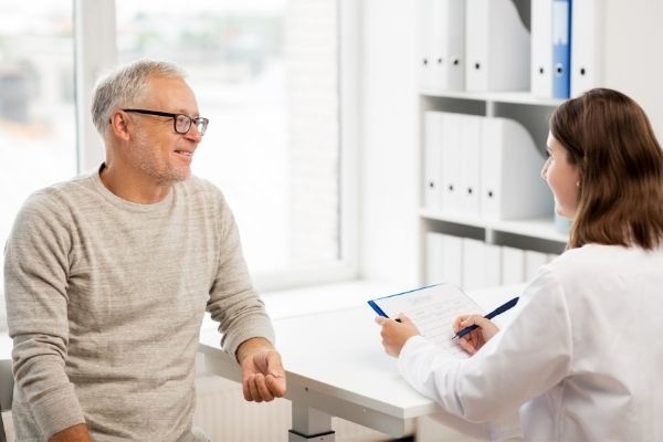 Female doctor speaking to male patient about pad