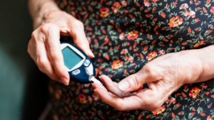 woman measuring her blood glucose levels managing her diabetes