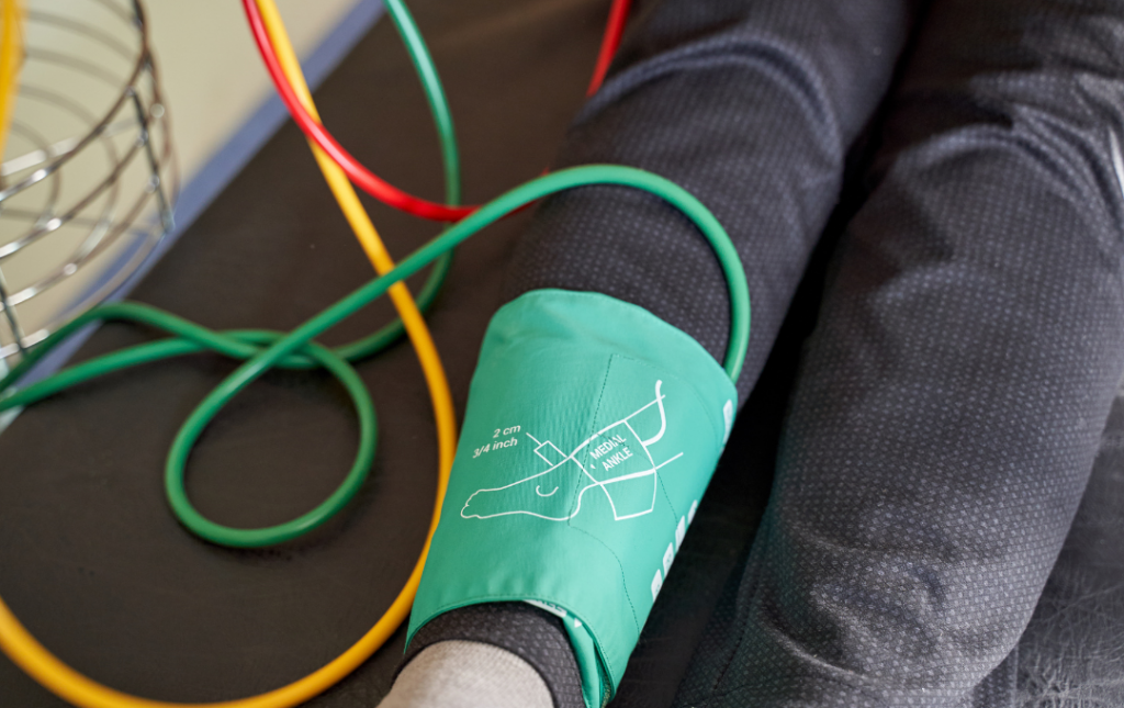 Ankle Brachial Index (ABI) test being performed on a patient's leg