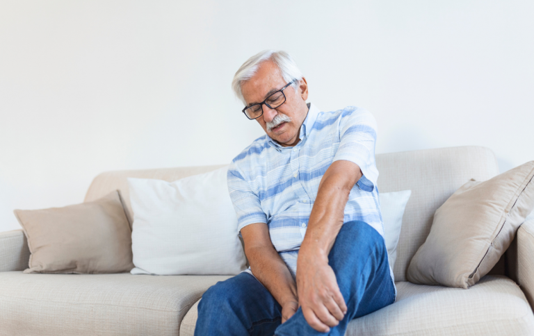 Man grasps his leg because it suddenly became painful, which could suggest acute limb ischemia.